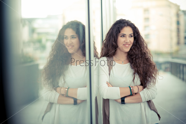 Beautiful curly long brunette hair moroccan woman in the city, stock photo
