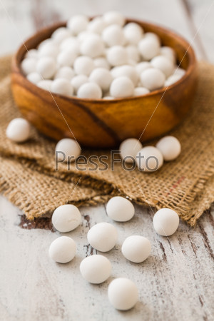 White roasted chickpeas in brown wooden bowl on linen napkin