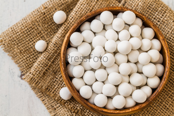 White roasted chickpeas in brown wooden bowl on linen napkin