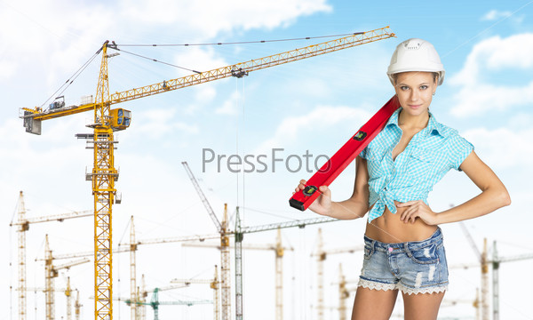 Woman in hard hat with large builders level on her shoulder