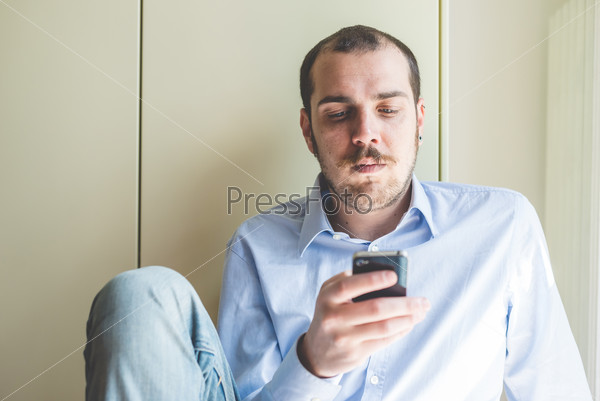 Elegant business multitasking multimedia man calling with smartphone at home, stock photo