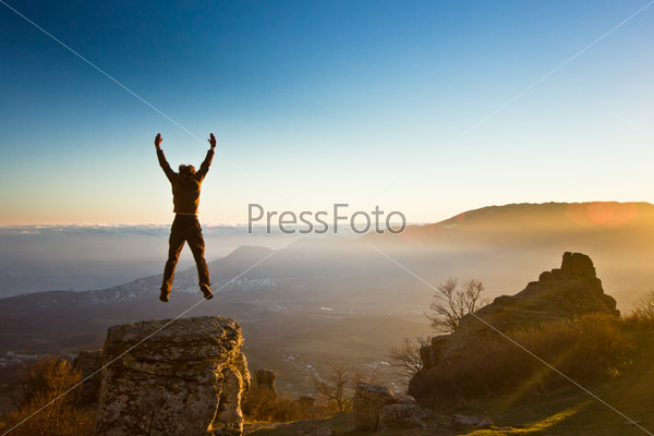 freedom man with hands up in the mountains against sun