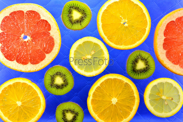 The blue background of the different types of citrus orange, lemon, grapefruit and kiwi