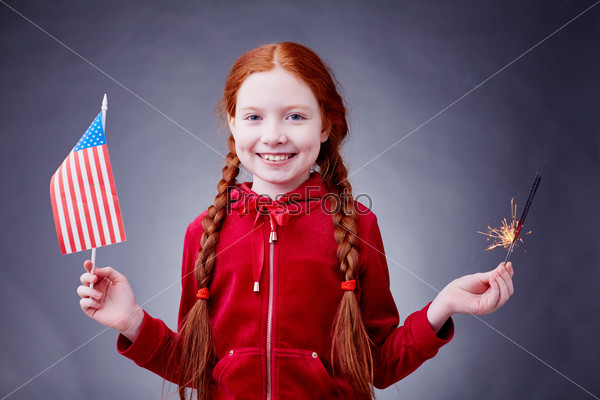 Red-haired girl with American flag and Bengal light