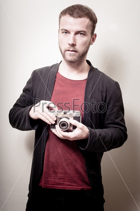 hipster stylish fashion man with old camera on gray background