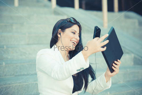 Beautiful long black hair elegant business woman with tablet in the city, stock photo