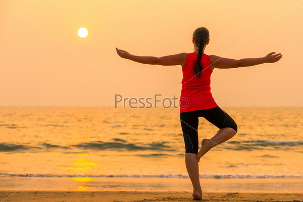 Girl on background of the sea balance on one leg, stock photo