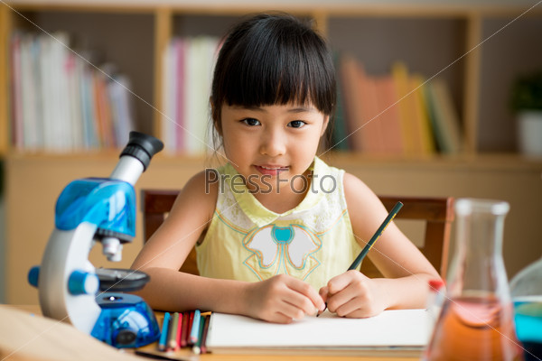 Vietnamese little girl drawing at the science lesson