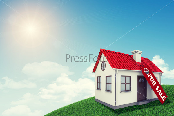 White house with red roof for sale on green grassy hill. Background sun shines brightly. Blue sky, stock photo