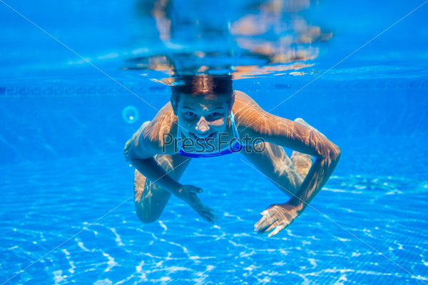 Portrait of underwater happy cute girl in swimming pool