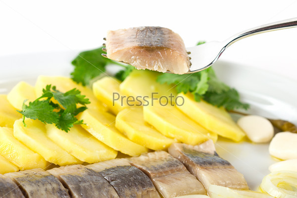 Portion of herring fish fillets with potato and onion