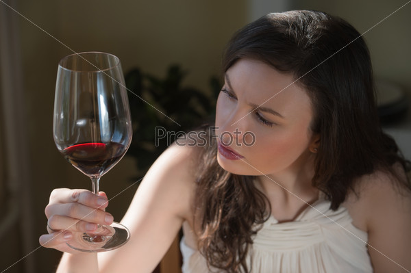 Молодая женщина пьет красное вино