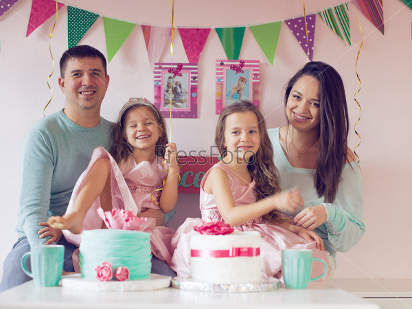 Family celebrating birthday princess party of two 6 years old children