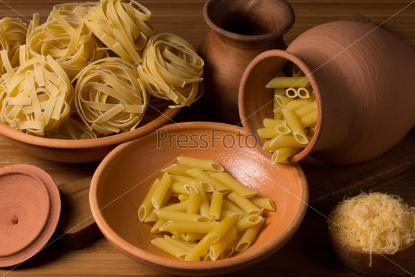Still life with pasta and ceramic ware in brown tones