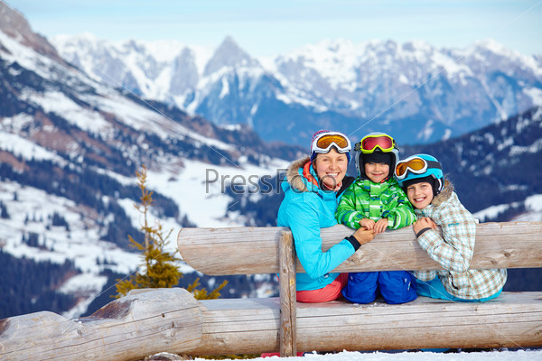 Ski, winter, snow, skiers, sun and fun - Two happy kids with mother enjoying winter vacations.