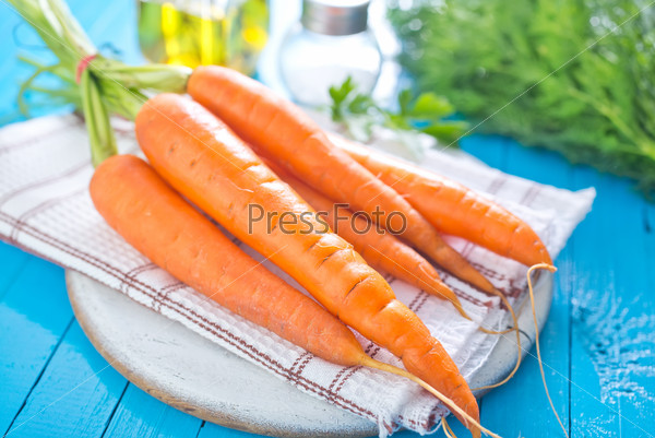 raw carrot on board and on a table