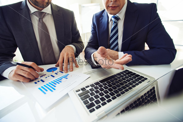Two men in suits searching for decision in financial issues, stock photo
