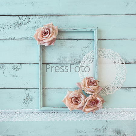 Wooden photo frame with lace and flowers on mint shabby chic background