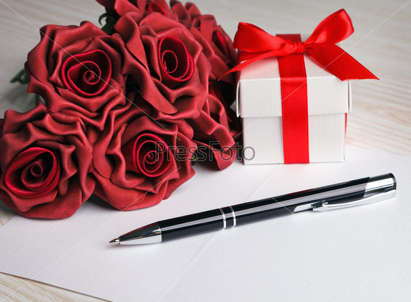 blank greeting  card with a pen,red roses and white gift box
