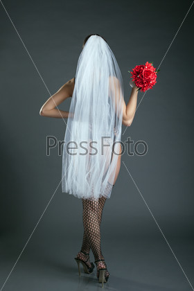 Slender model posing in veil and black stockings