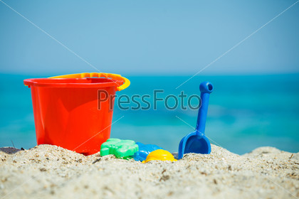 Children\'s beach toys - buckets, spade and shovel on sand on a sunny day