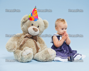 A little sweet girl with teddy in her first birthday.