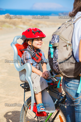 child sitting by bicycle in crash helmet