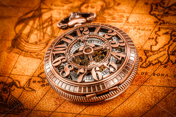 Vintage Antique pocket watch on an ancient world map in 1565..