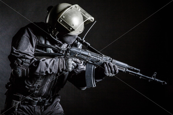 Russian special forces operator in black uniform and bulletproof helmet
