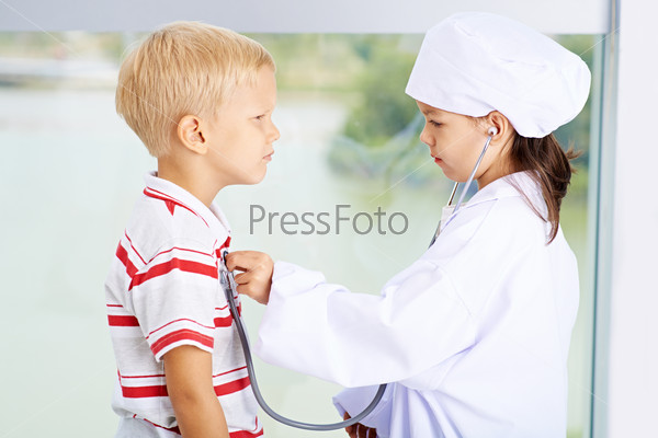 Children playing doctor and patient, side view