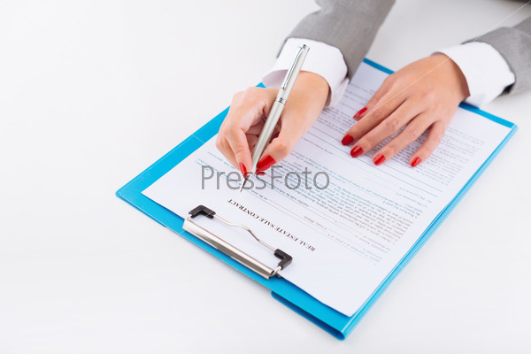 Hands of broker filling real estate sale contract