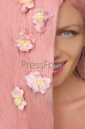 woman with pink hair and flowers looking to side