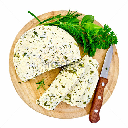 Homemade round cheese with herbs and spices, knife on a round wooden board isolated on white background