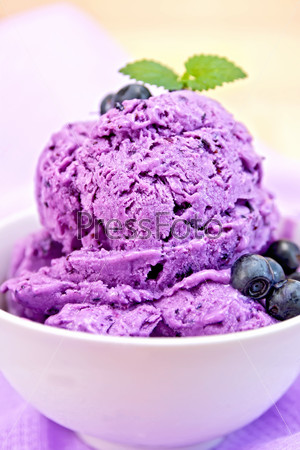 Ice cream blueberry with mint in bowl on napkin