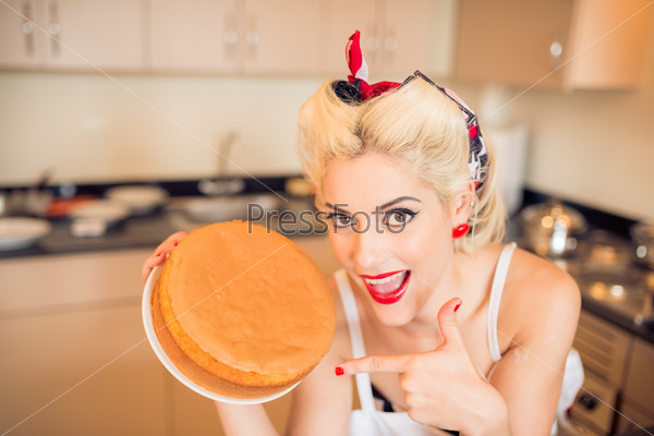 Attractive retro housewife showing the cake she made