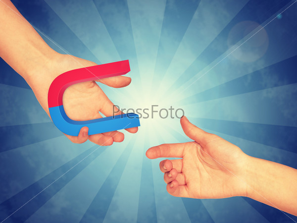 Right hand passing blue and red magnet. Abstract blue background