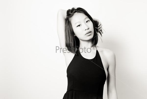Beautiful sexy asian woman posing in black dress, black and white portrait