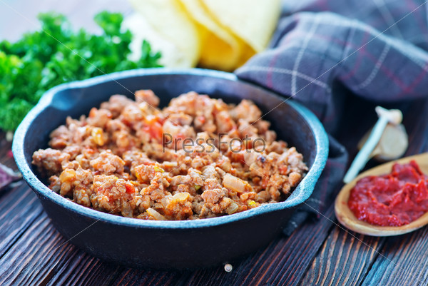 a bowl of fried ground meat with tomatoes ready for tacos