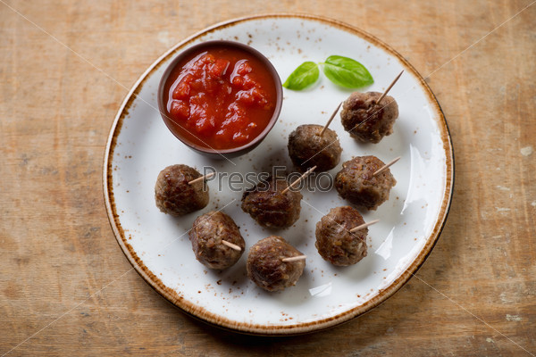 Meatballs on skewers with dipping sauce, high angle view, studio shot