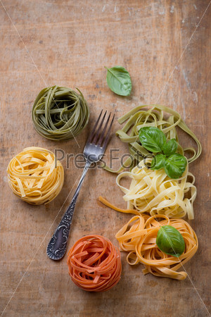 Tagliatelle of italian flag colors on a rustic wooden surface