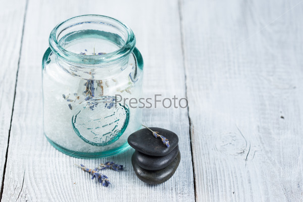 Jar with sea salt and spa stones on a white background wooden