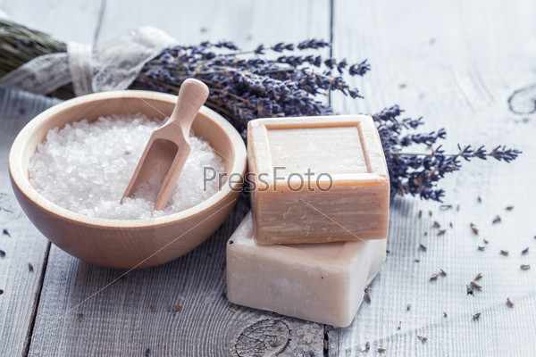 Natural soap, lavender, salt on a wooden board, hygiene items for bath and spa.