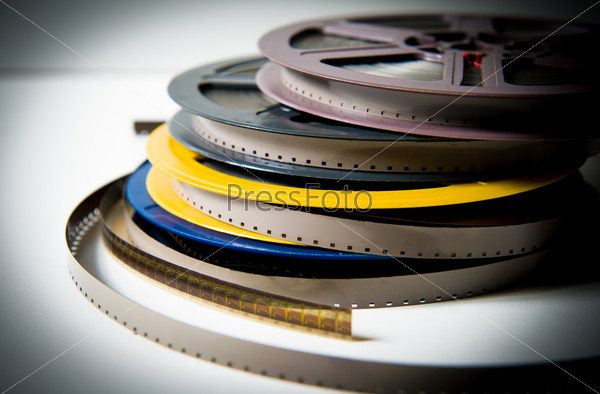 Pile of grey, blue, yellow and purple 8mm super8 movie reels on white background, vintage look and color effect