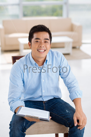 Cheerful young self-employed man with a business document