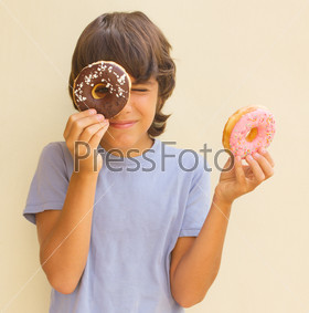 teen  caicasian boy playing with  donuts