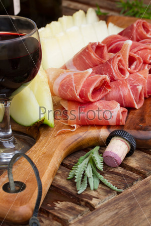 spanish tapas  - slices of cured pork ham jamon with melon and wine