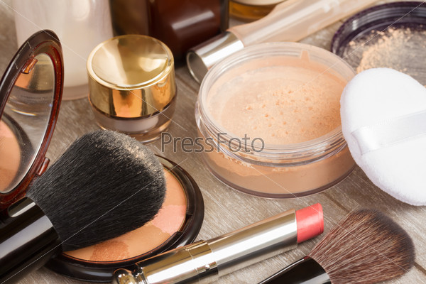 Basic make-up products on table - foundation, powder and lipstick