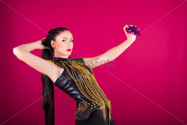 Portrait of a style model woman using perfume on a pink background.