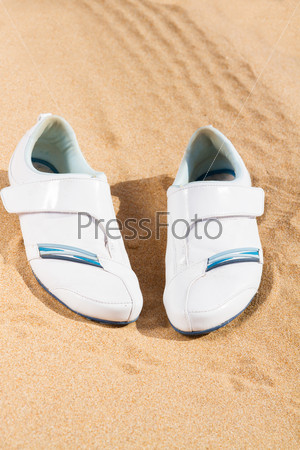 white sneakers in sand