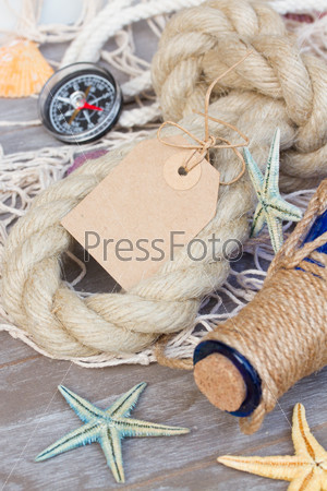 empty paper note with compass fishing net , marine rope and bottle